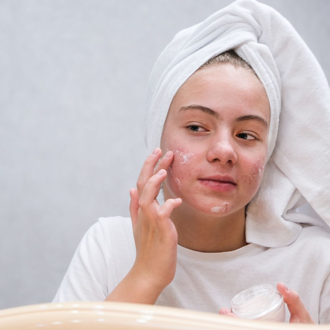 A bottle of OmMade Organic Skincare Oil Cleanser on a green background.